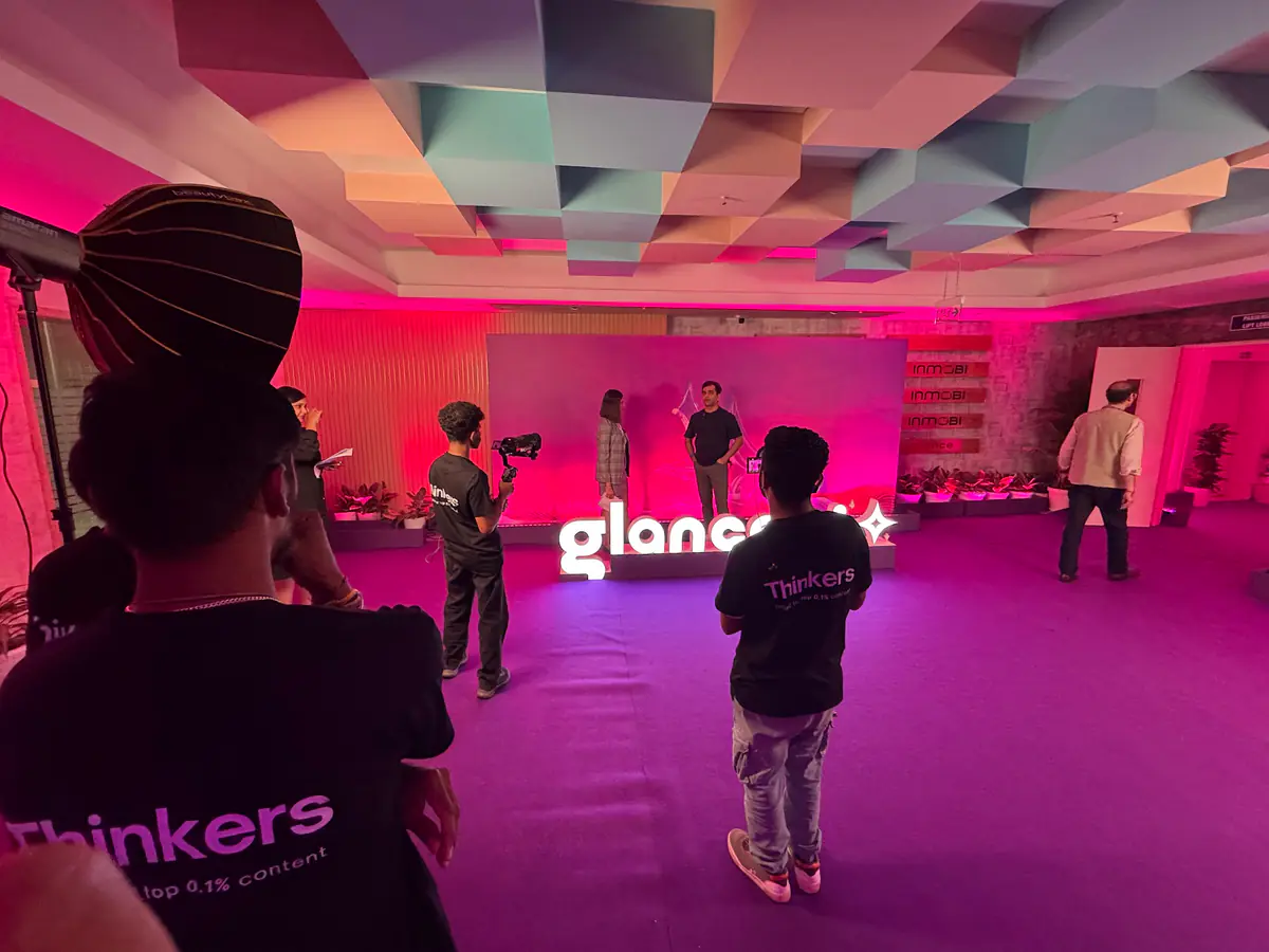 The crew filming on the pink-lit Glance AI launch set